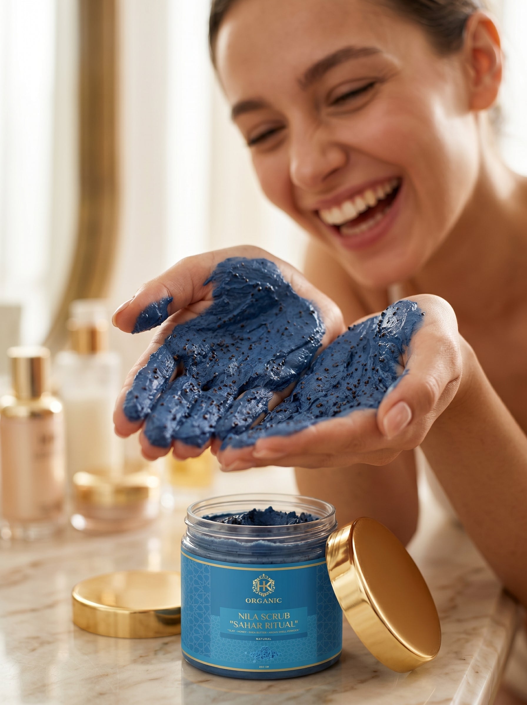Woman holding blue scrub in hands with a jar of the same scrub on a marble surface.