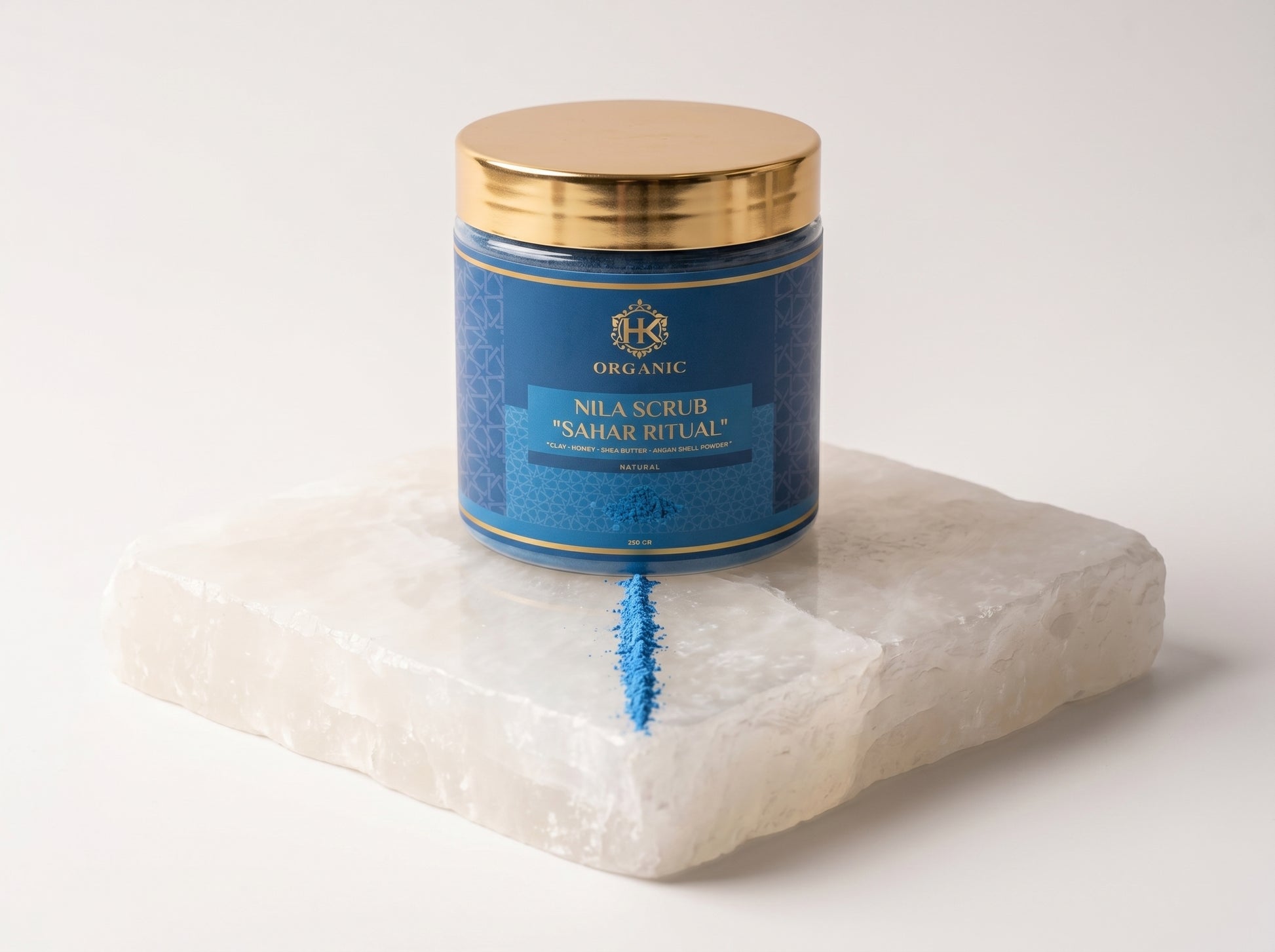Blue scrub container with gold lid on a white stone block