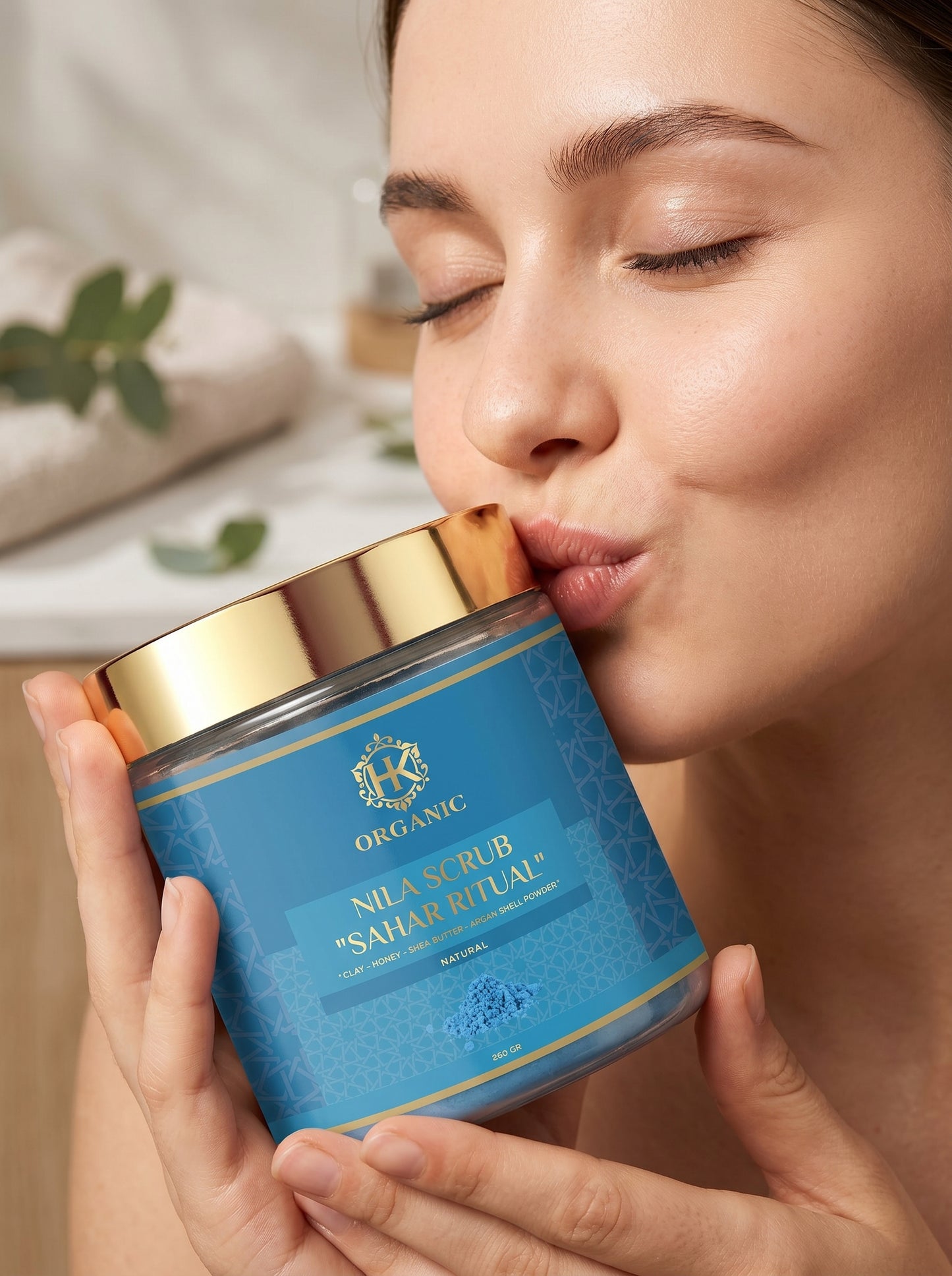 Person holding a blue scrub container with gold lid, close-up of face.