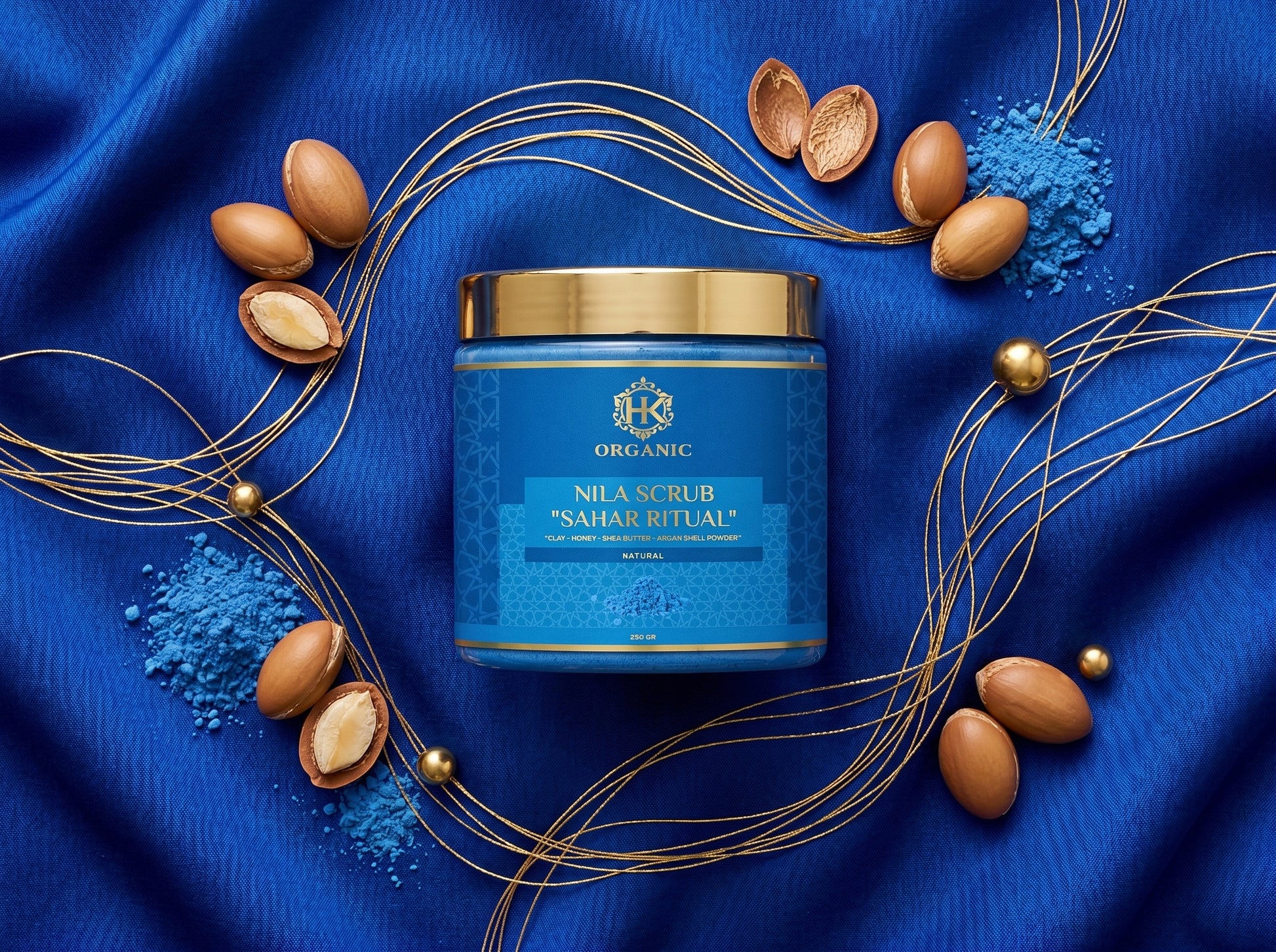 Blue scrub jar with almonds and blue powder on a blue fabric background