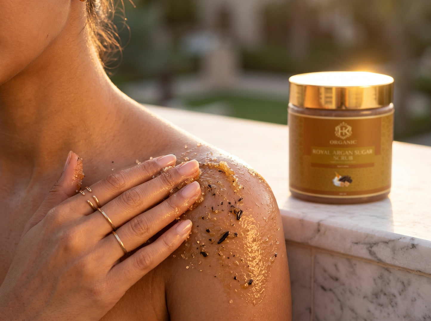 Person applying a brown cream to their shoulder with a jar of the same cream in the background.