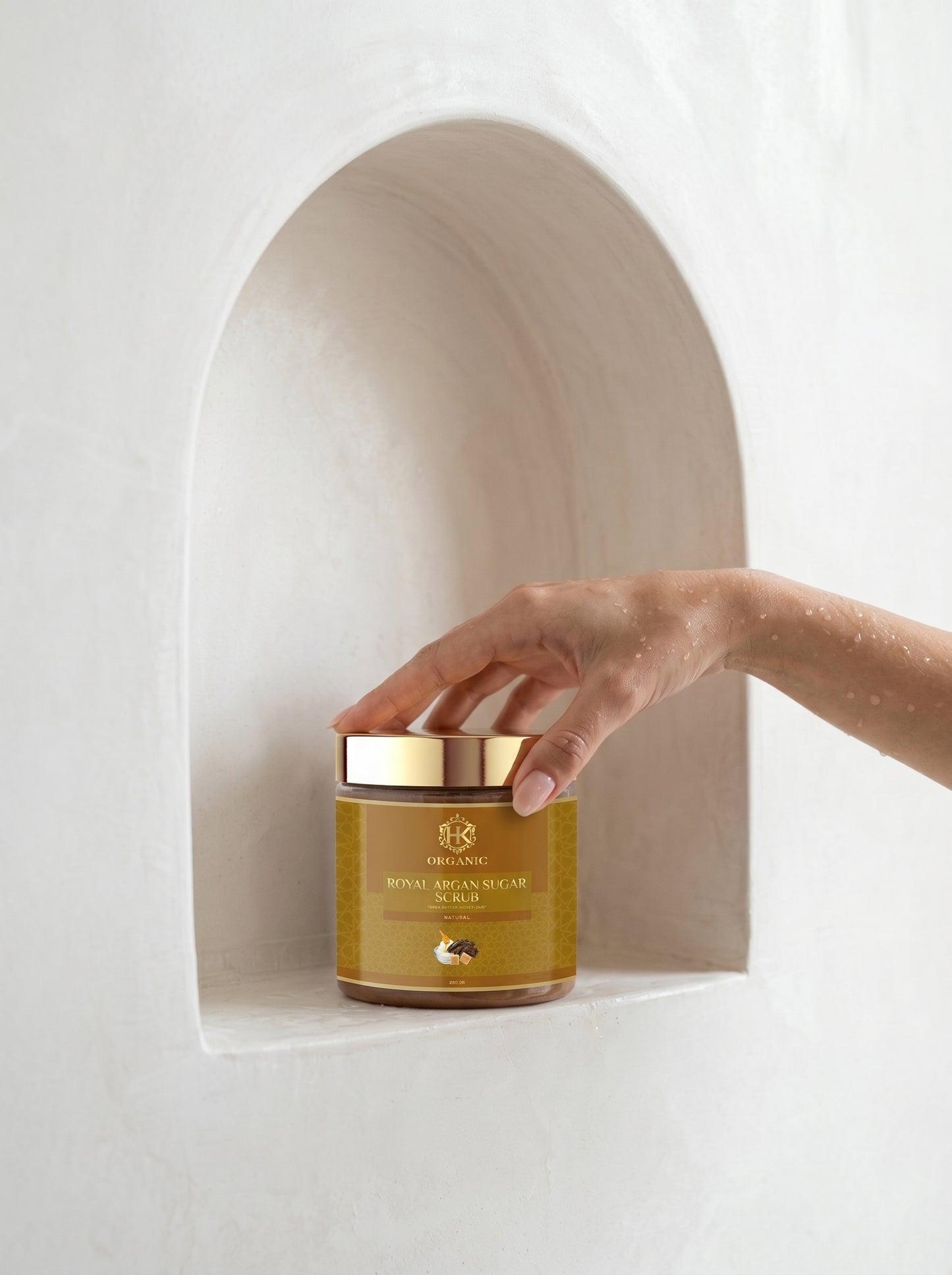 Hand reaching for a jar of Royal Jelly on a white background
