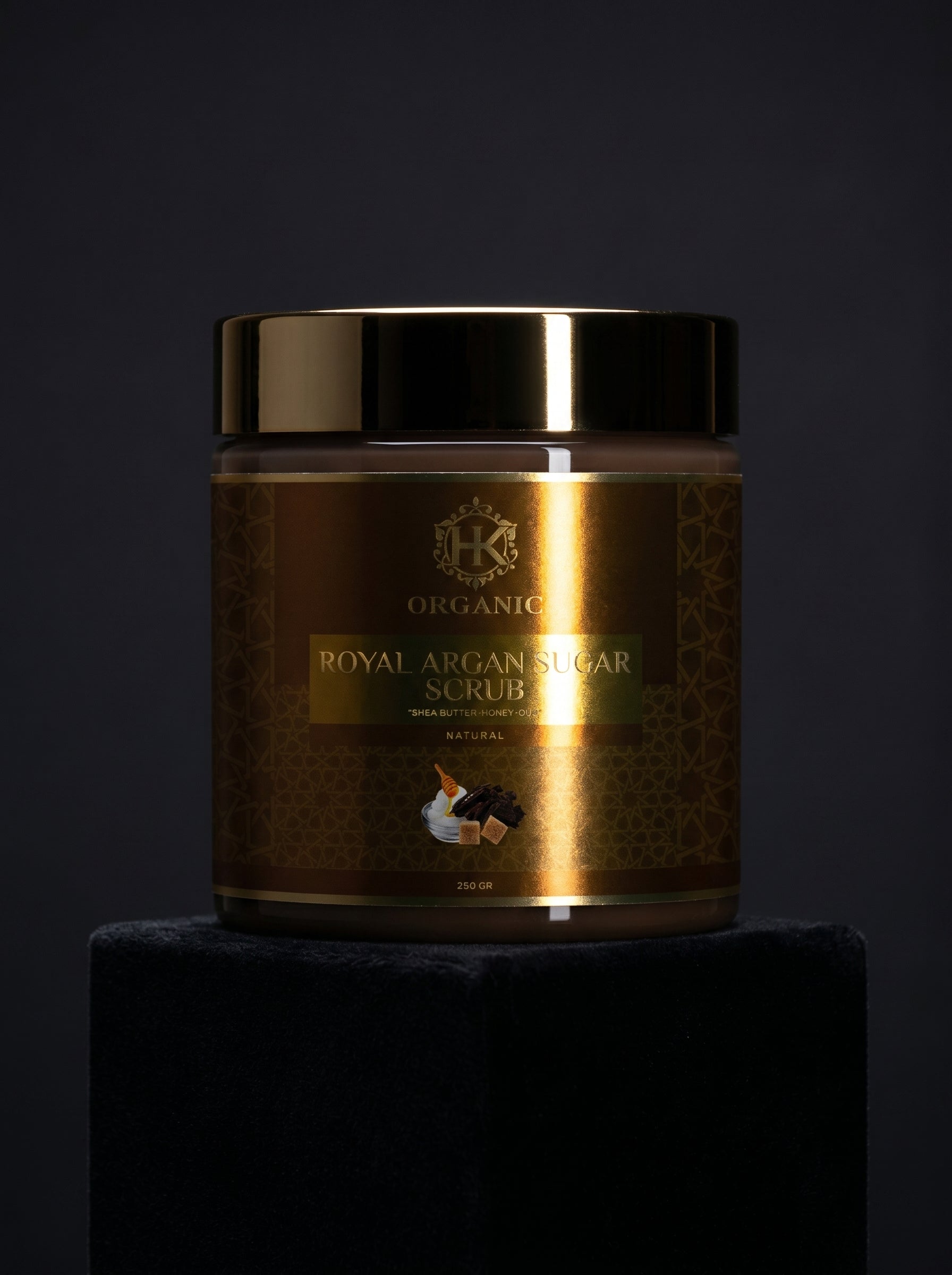 Gold jar of organic royal argan sugar scrub on a dark background