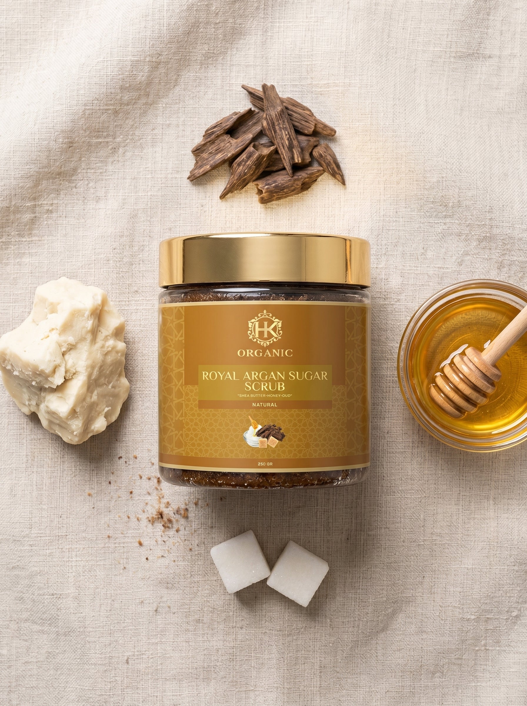 Jar of organic royal argan sugar scrub with honey and sugar cubes on a textured surface