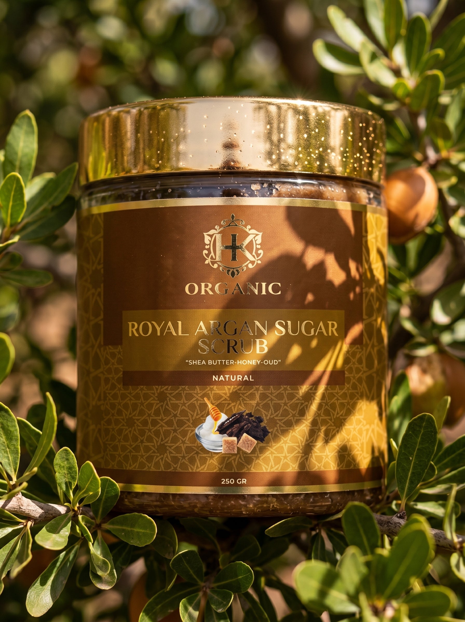 Jar of Organic Royal Argan Sugar Scrub on a background of green leaves and argan fruits.