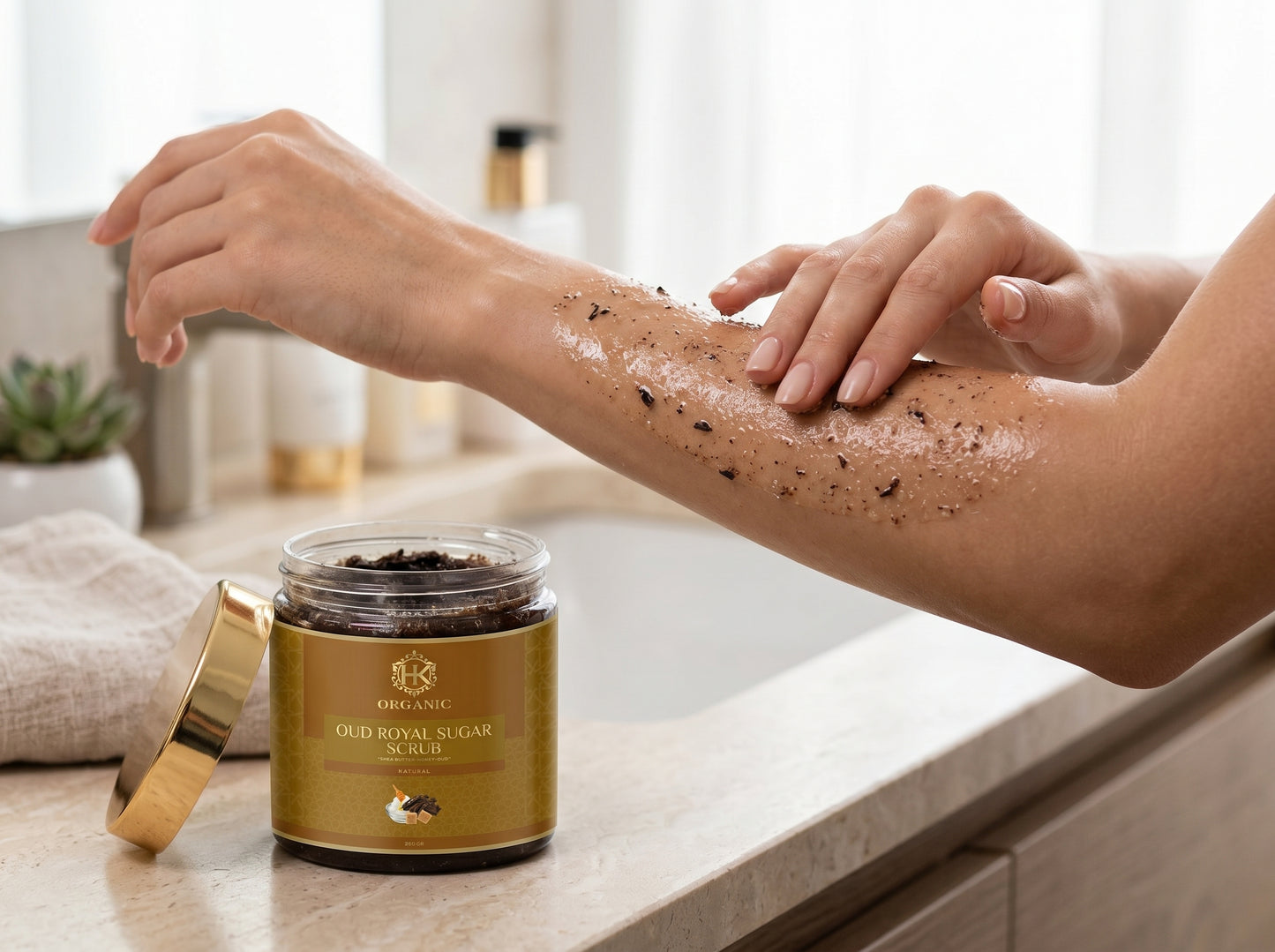 Person applying a scrub to their arm with a jar of scrub on a counter.