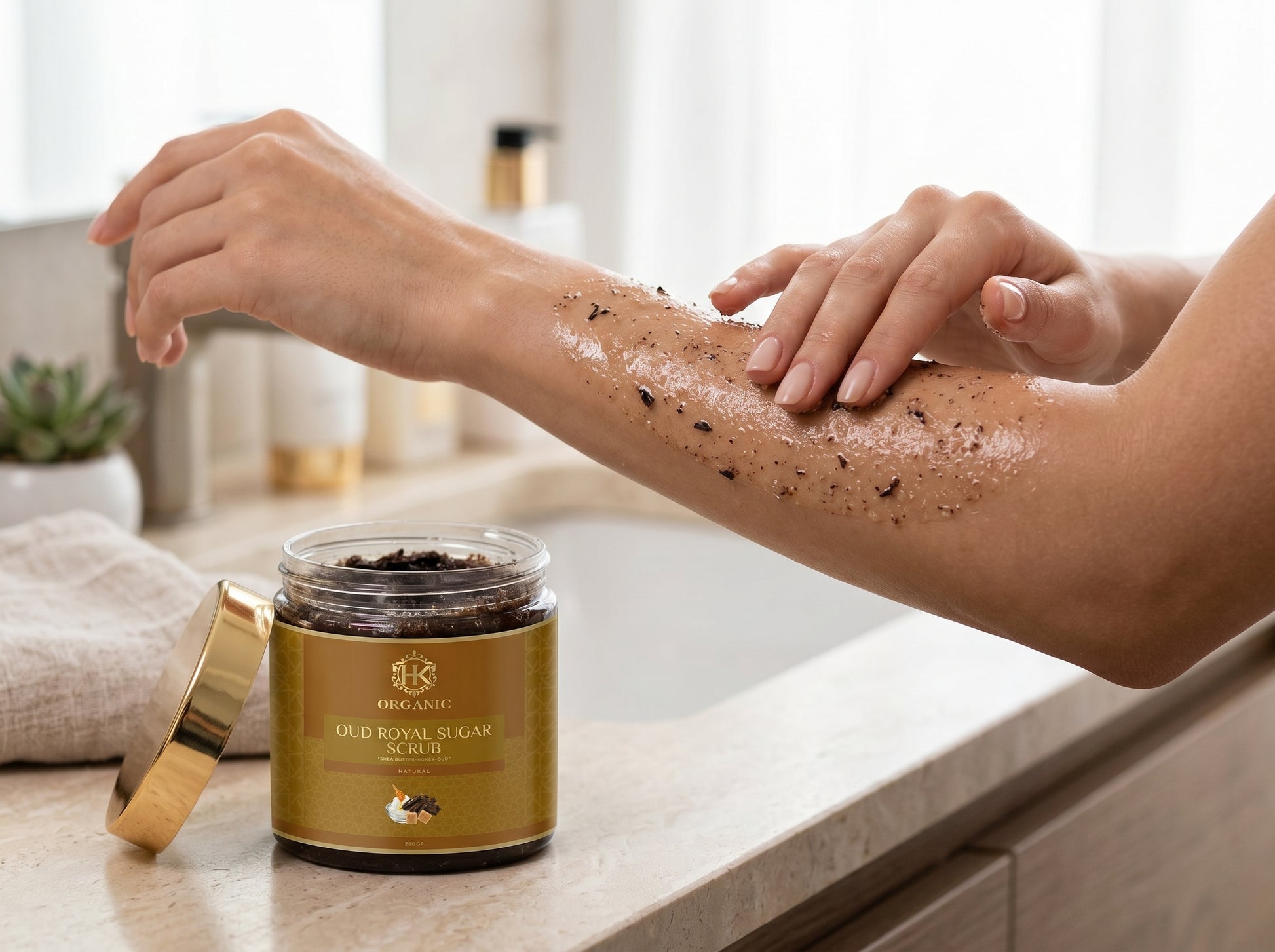Person applying a scrub to their arm with a jar of scrub on a counter.