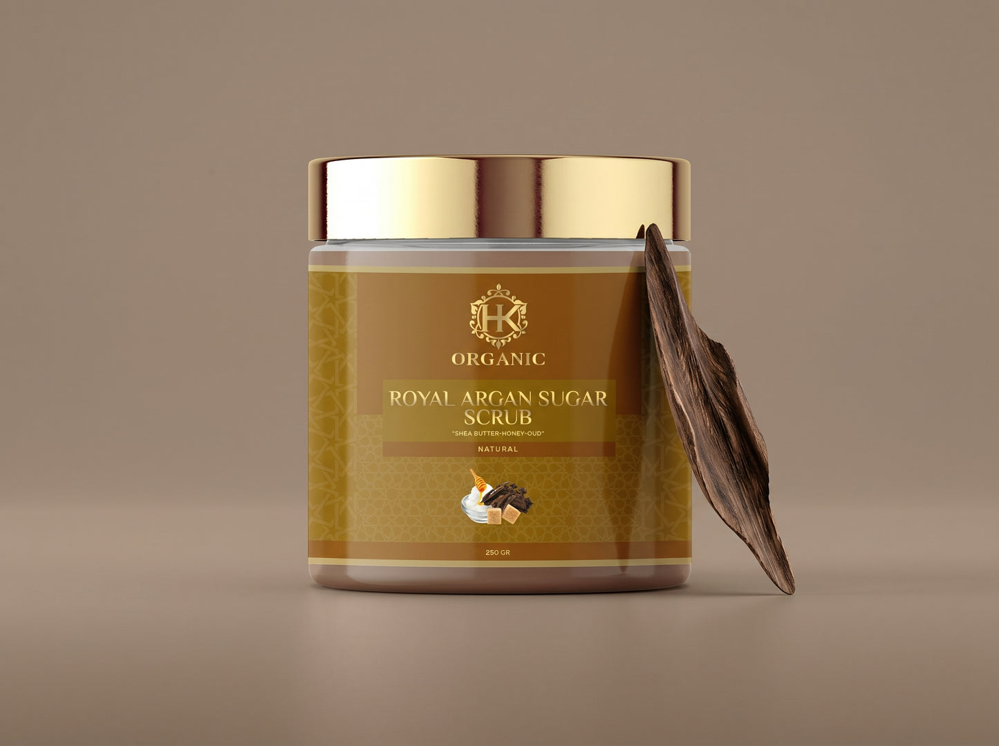 Jar of organic royal argan sugar scrub with a gold lid on a brown background