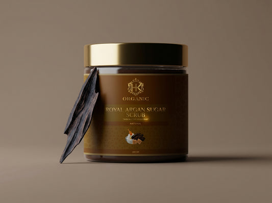 Jar of organic royal argan sugar scrub with a gold lid on a brown background