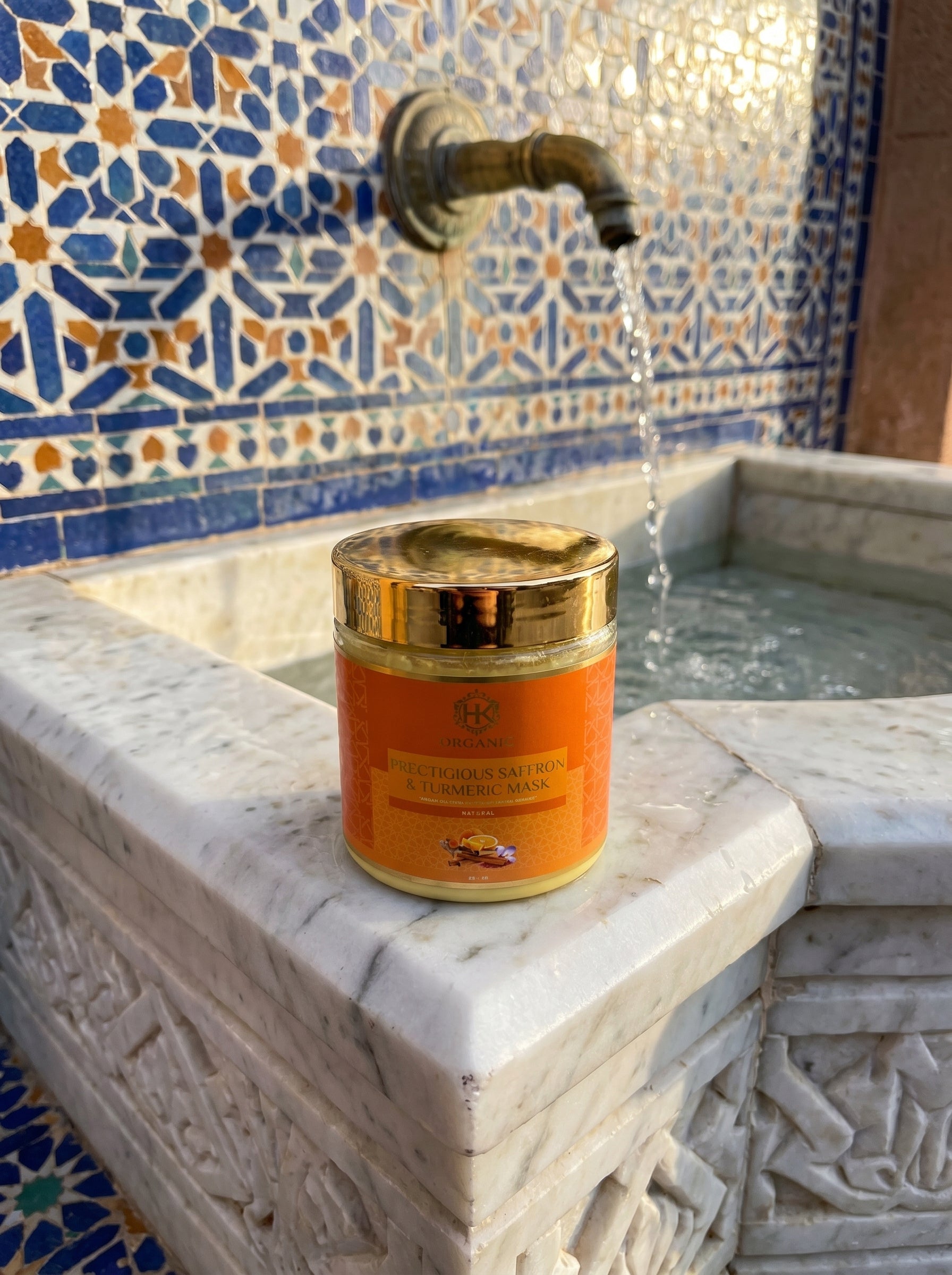 Jar of cosmetic cream on a marble ledge with a decorative tiled wall in the background