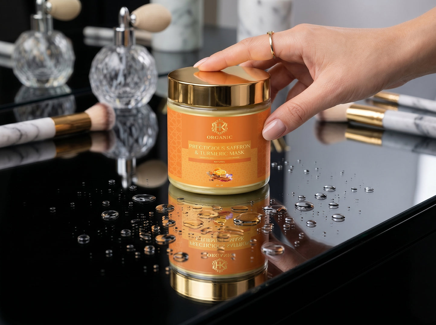 Hand holding a jar of skincare product with turmeric on a reflective surface with decorative items in the background