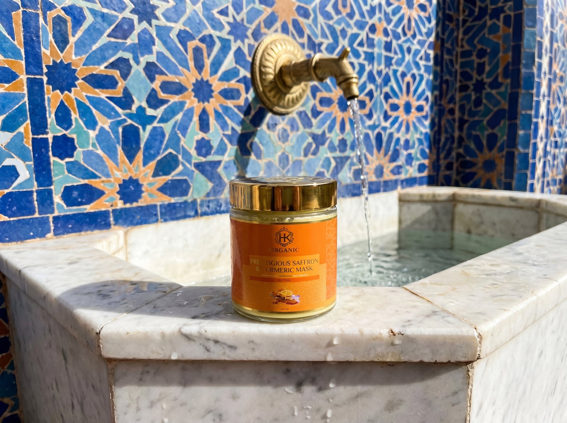 Jar of olive oil on a marble surface with a decorative tiled wall in the background