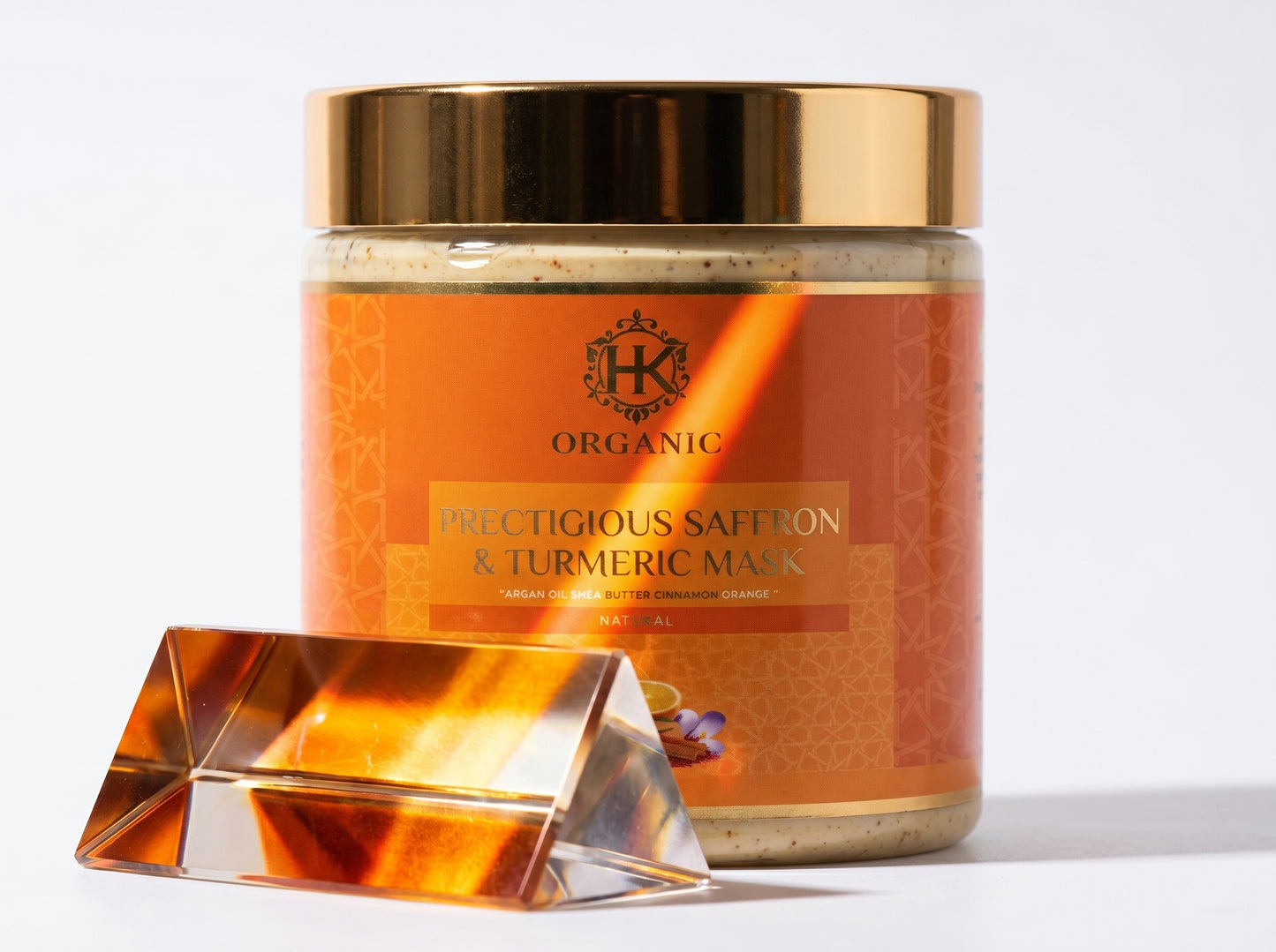 Jar of organic saffron and turmeric mask with a decorative stand on a white background