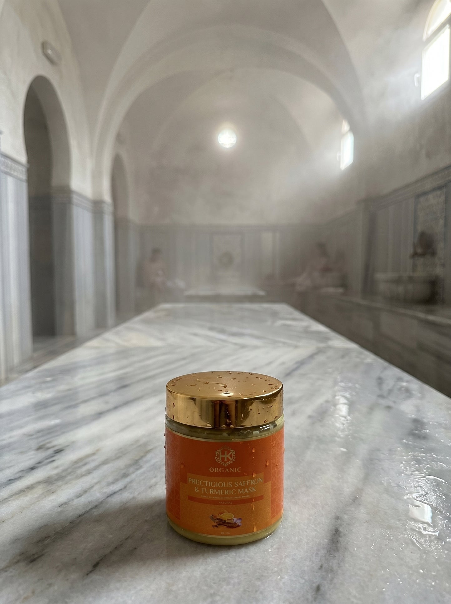 Jar of turmeric on a marble surface with classical architecture in the background