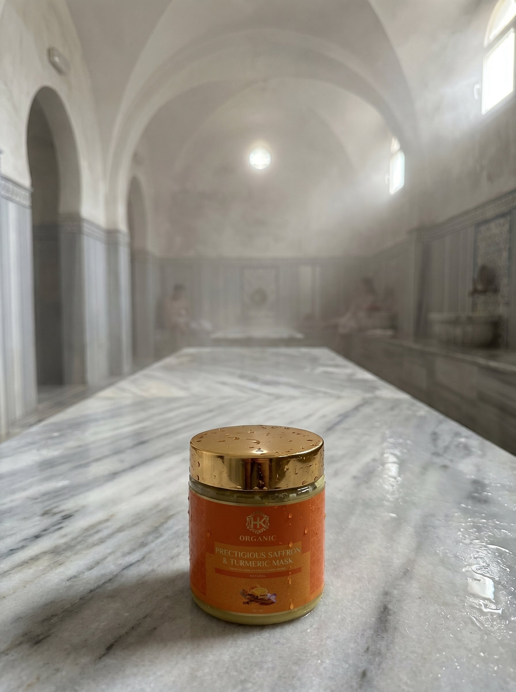 Jar of turmeric on a marble surface with classical architecture in the background