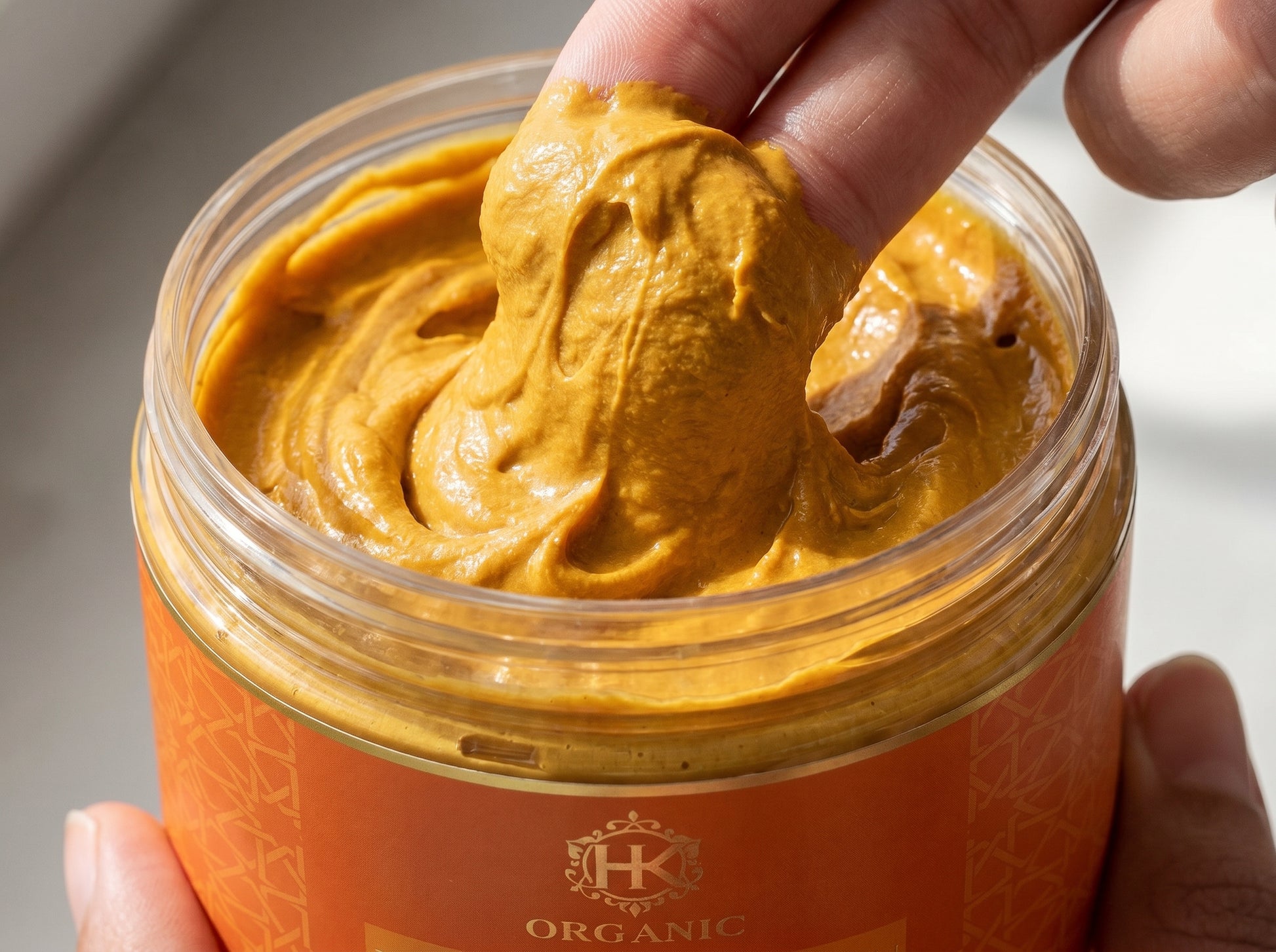 Hand holding a jar of organic turmeric with a visible brand logo.