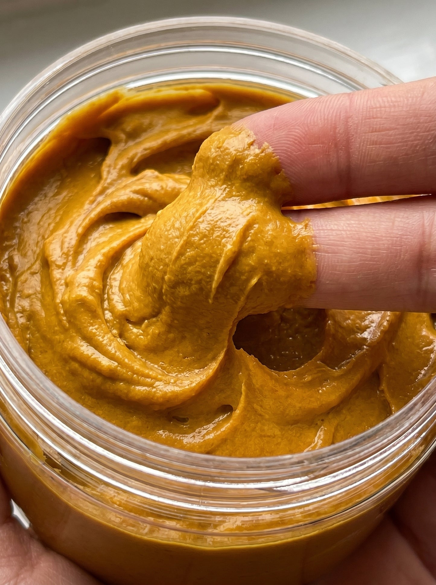 Hand scooping turmeric from a jar