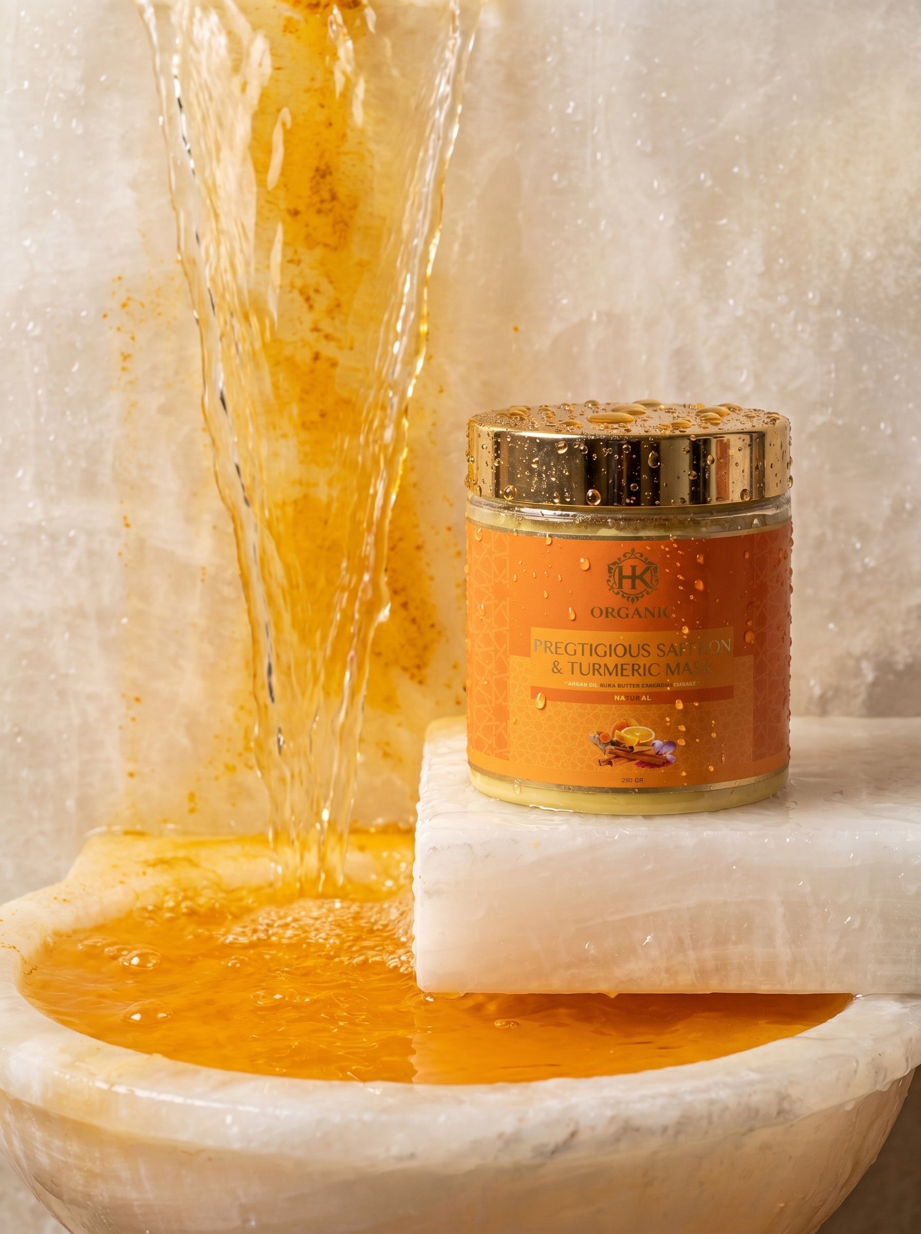 Jar of honey with a gold lid on a marble surface with honey flowing around it.