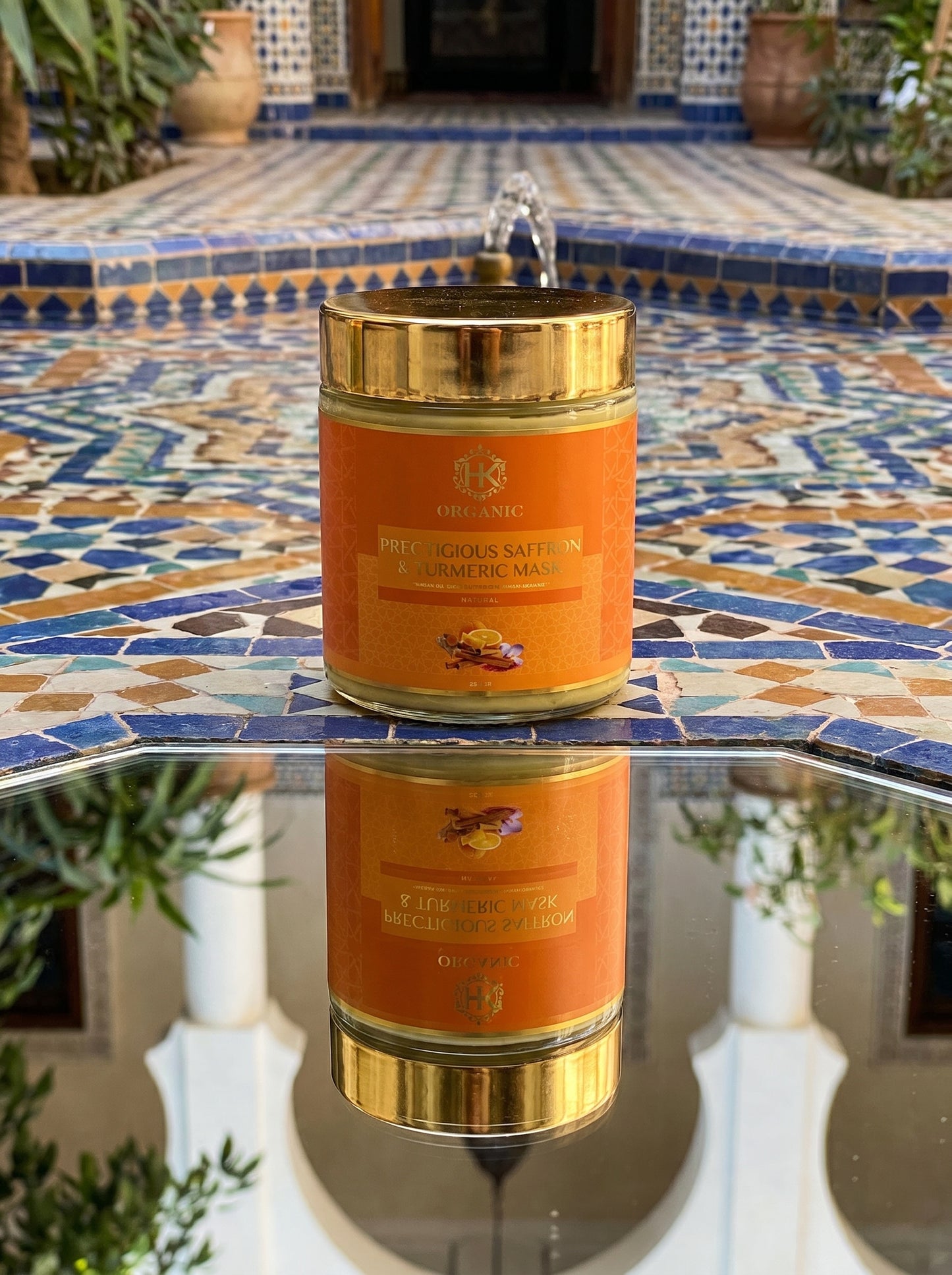 turmeric and gold jar on a mosaic table with plants in the background