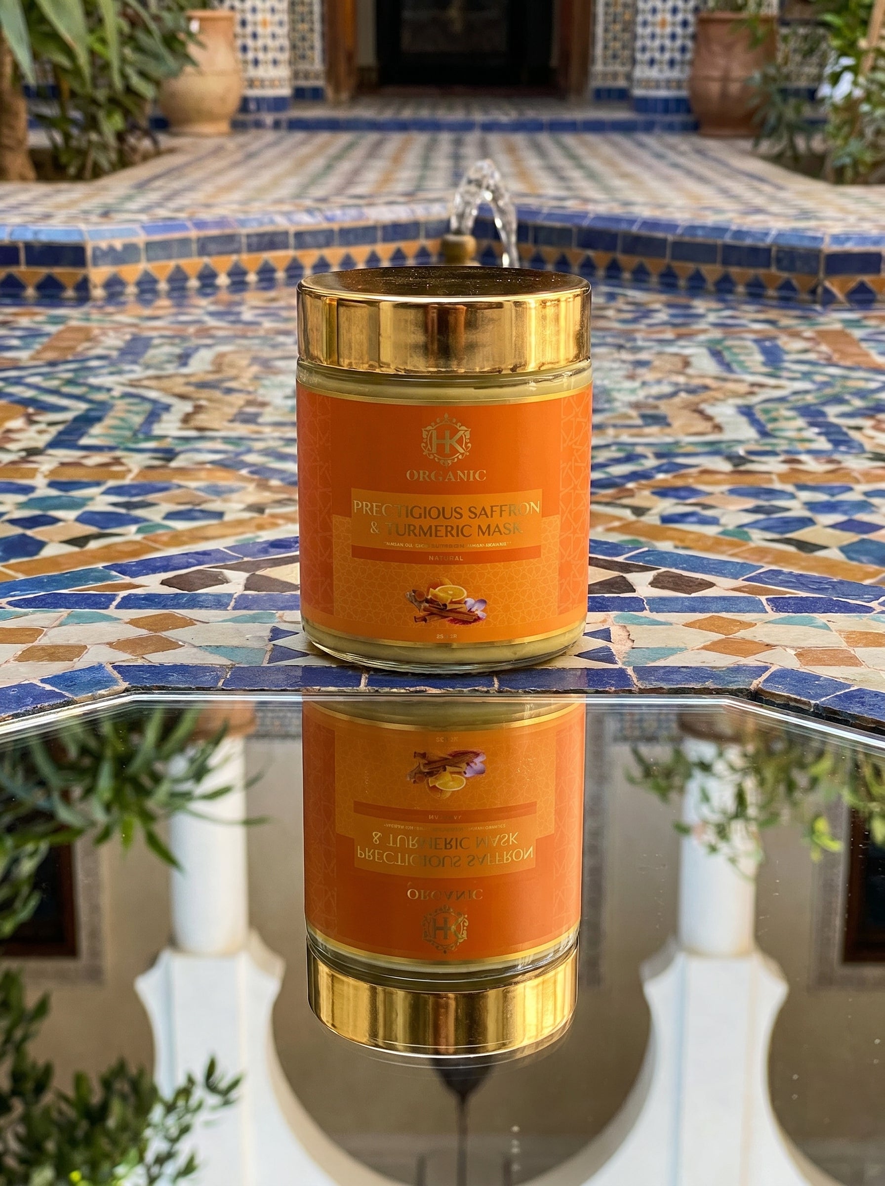 turmeric and gold jar on a mosaic table with plants in the background