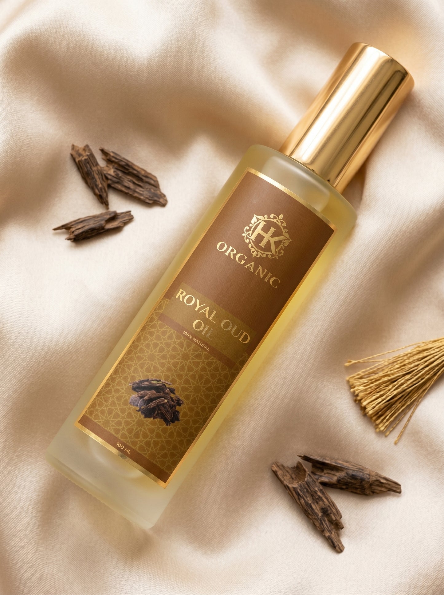 HK Organic Royal Oud oil bottle on a beige fabric background