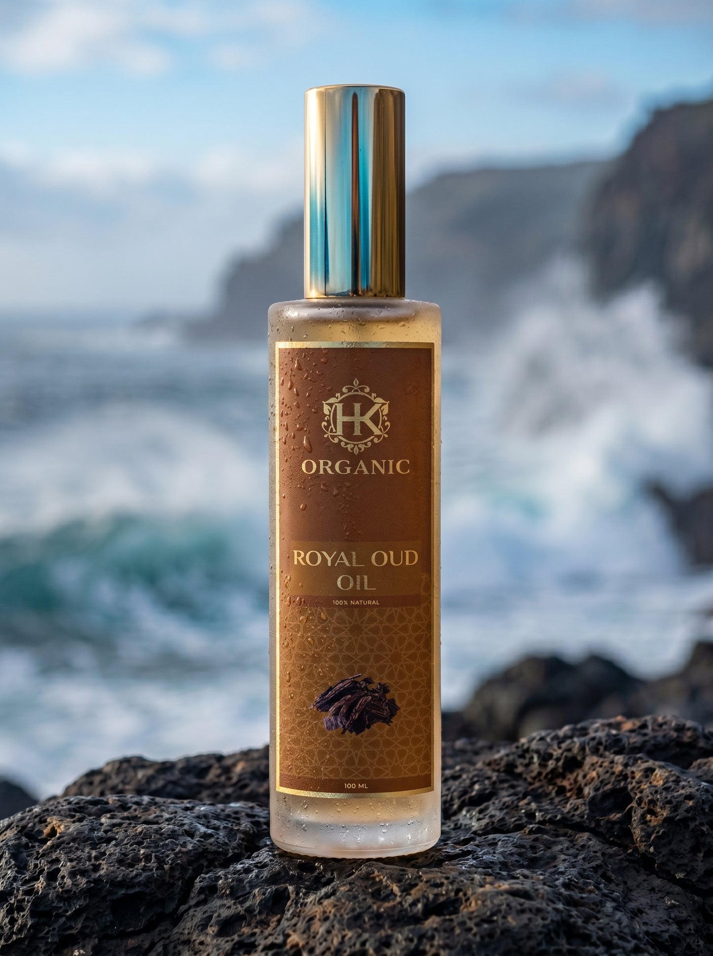 Bottle of organic royal oud oil on a rocky surface with ocean background