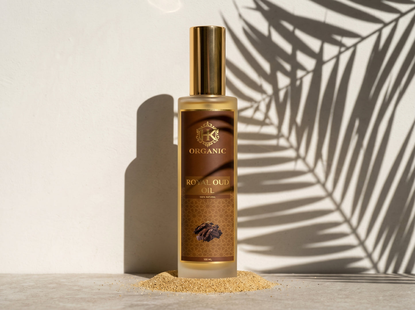 Bottle of organic royal oud oil with a palm leaf shadow on a light background