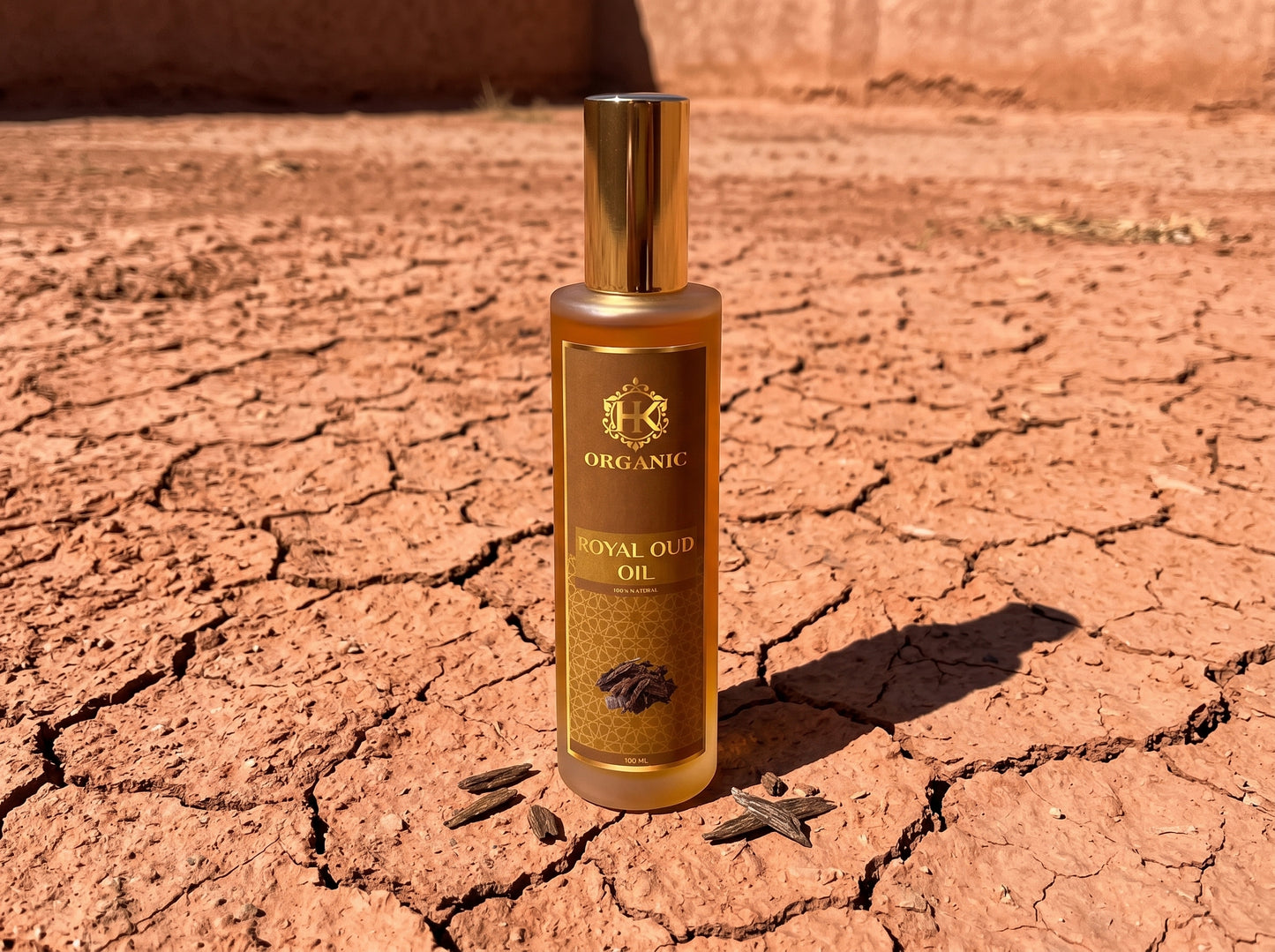 Bottle of organic royal oud oil on a cracked desert floor