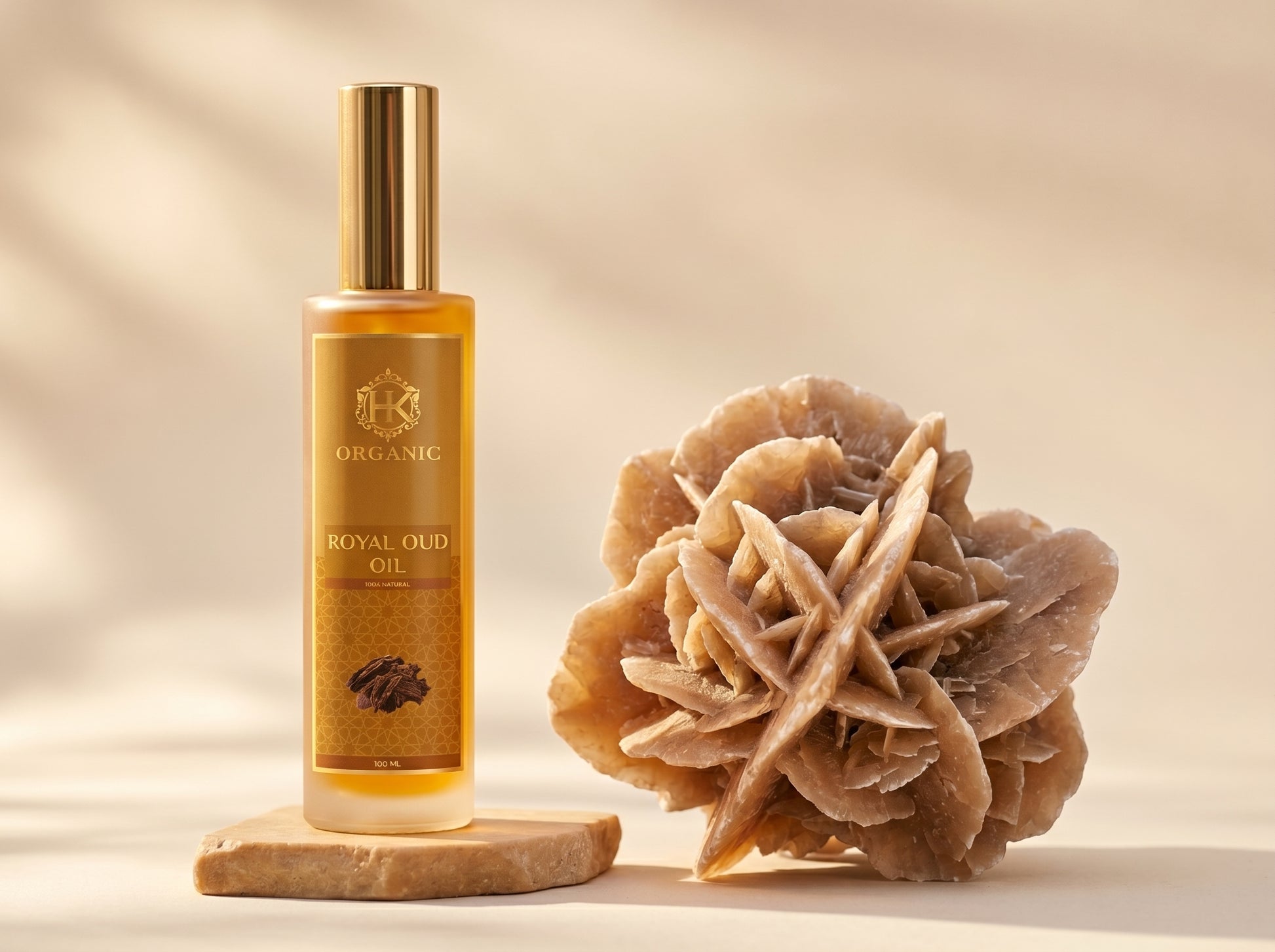 Bottle of organic royal oud oil with a decorative stone on a beige background