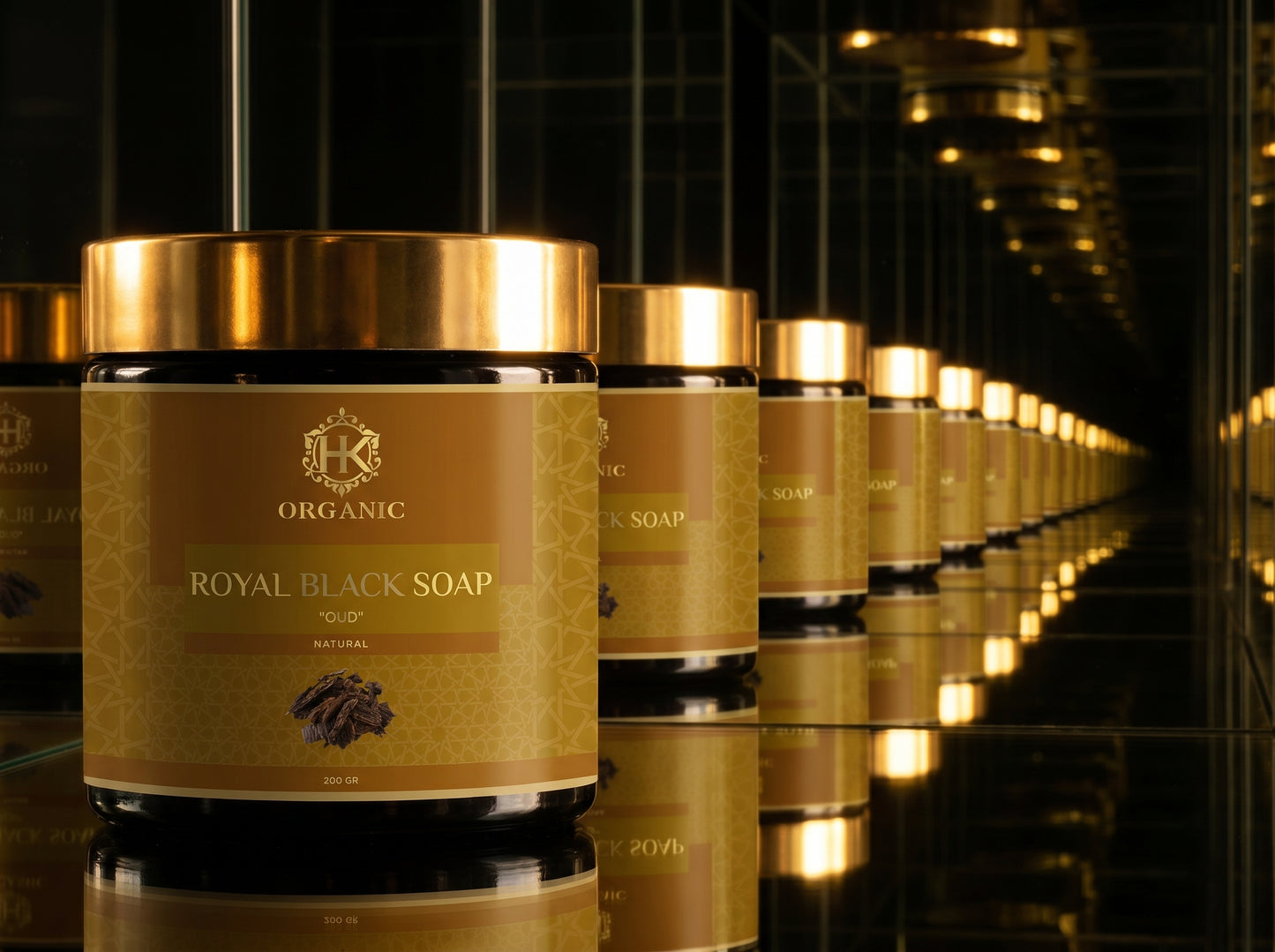 Row of Royal Black Soap jars with gold labels in a reflective setting