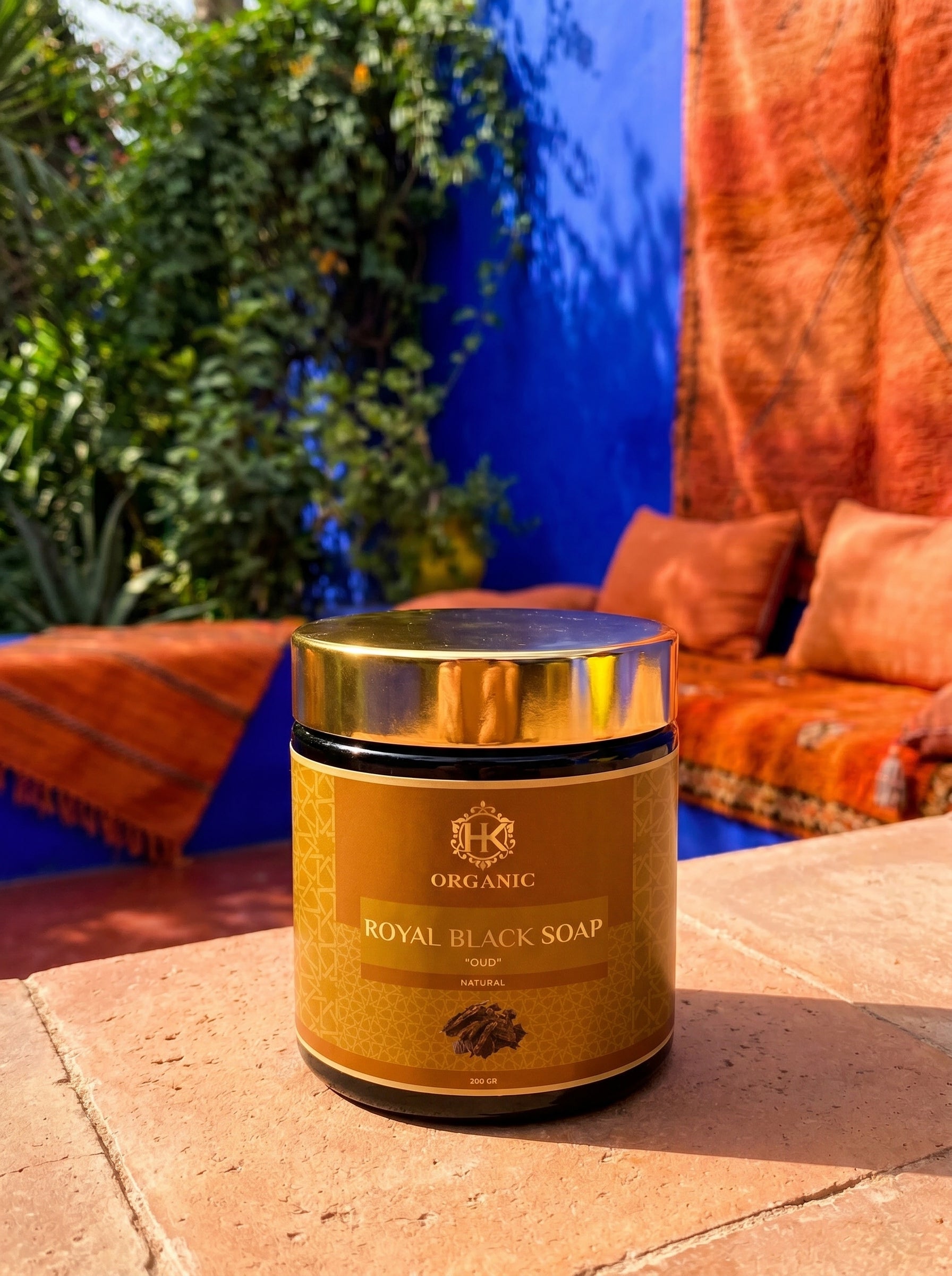 Jar of Royal Black Soap on a textured surface with a colorful background