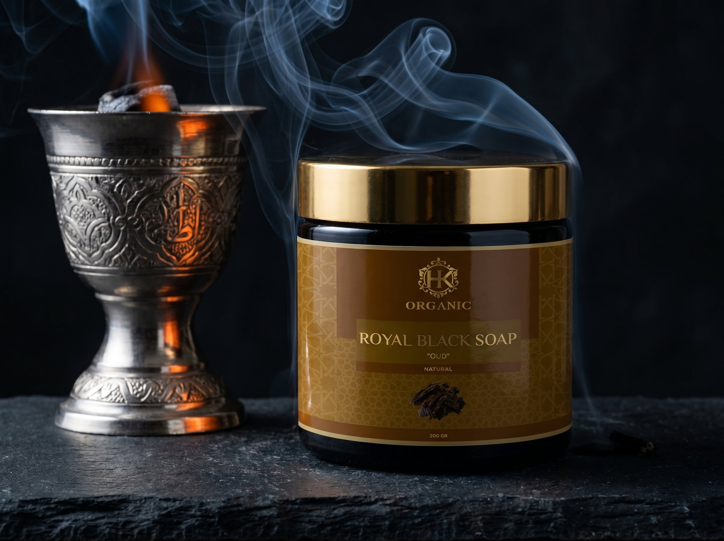 Jar of Royal Black Soap with a decorative metal container and flame on a dark background