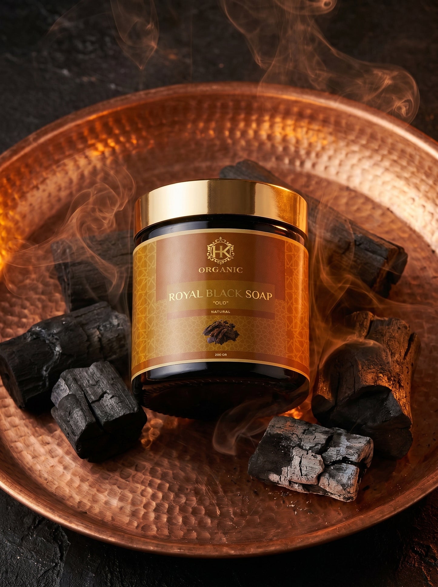 Royal Black Soap jar on a textured surface with charcoal and smoke