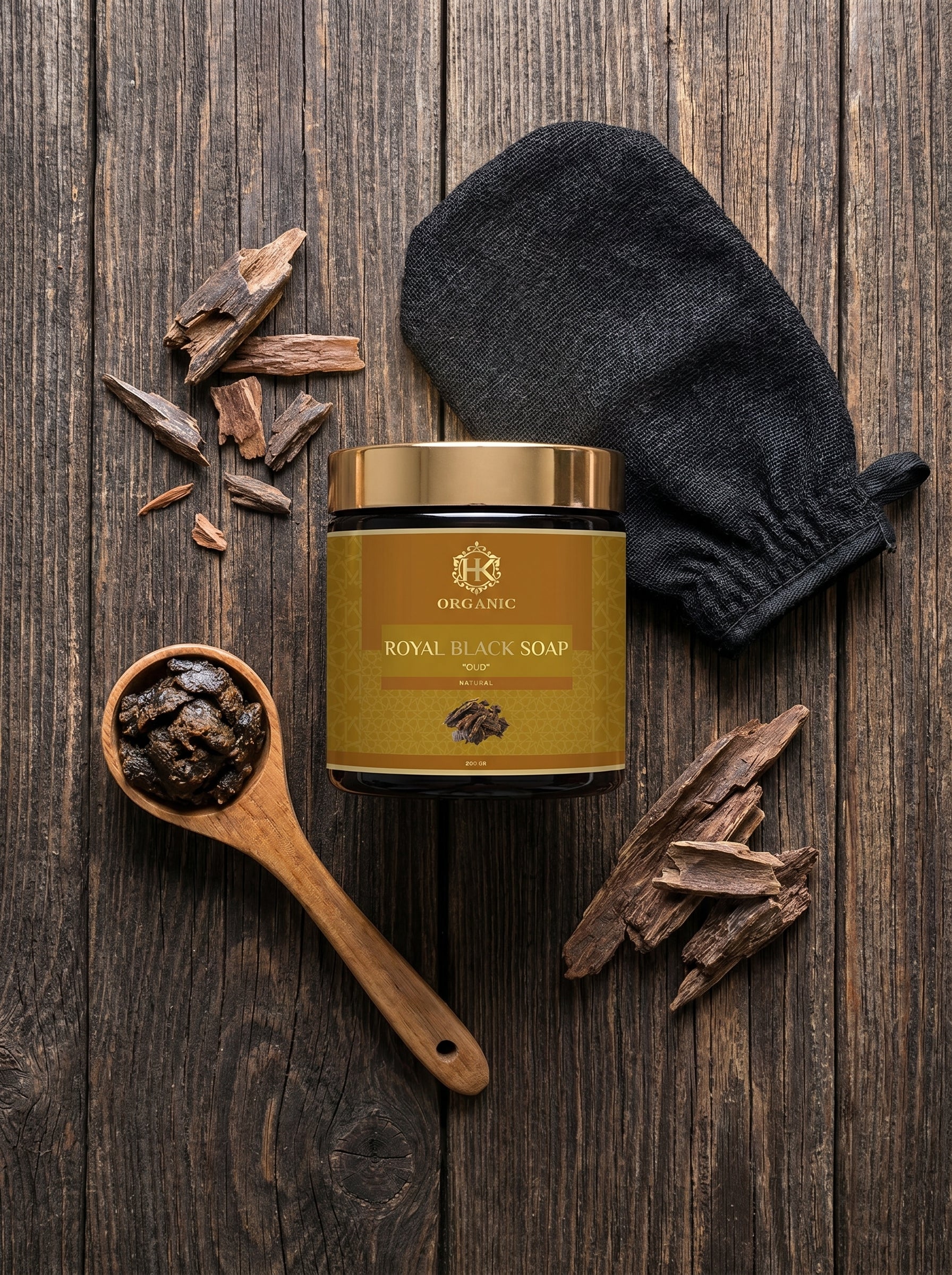 Jar of Royal Black Soap with wooden spoon, glove, and soap pieces on wooden surface